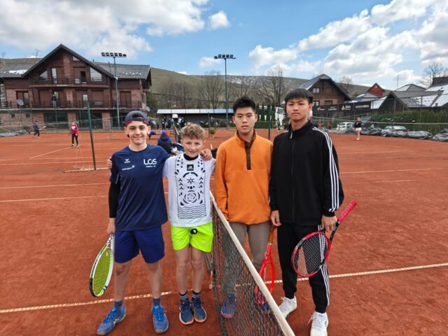 Die Teilnehmenden Tennisspieler vor einem Tennisnetz