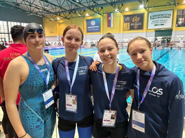 Das Schwimmteam steht gemeinsam im Schwimmbad